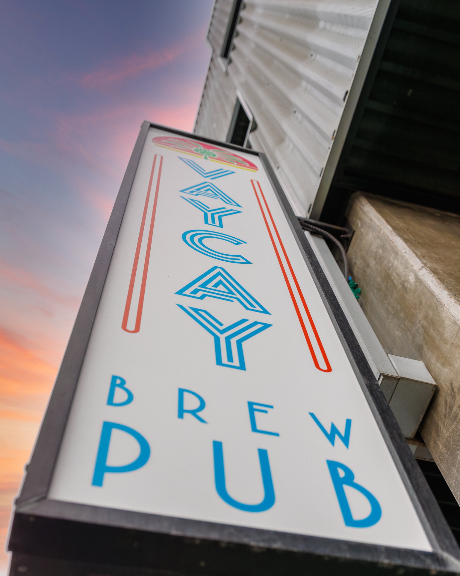 Vaycay Brew Pub exterior sign at sunset